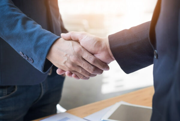 kündigung des geschäftsführers; Zwei Personen schütteln sich die Hand bei einem Businessdeal